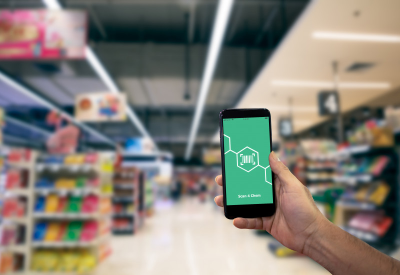 Eine Hand hält ein Smartphone in einem Geschäft