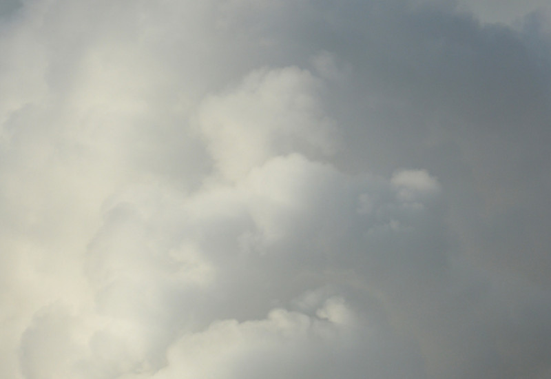Ein rauchender Schornstein vor bewölktem Himmel.