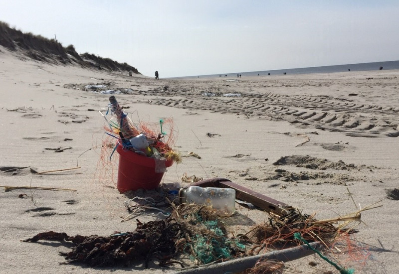 Müll liegt am Sandstrand, vor allem Plastik- und Fischereimüll. 
