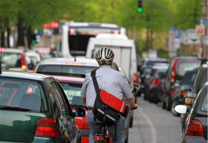 Ein Fahrradfahrer in einem Stau mit Autos