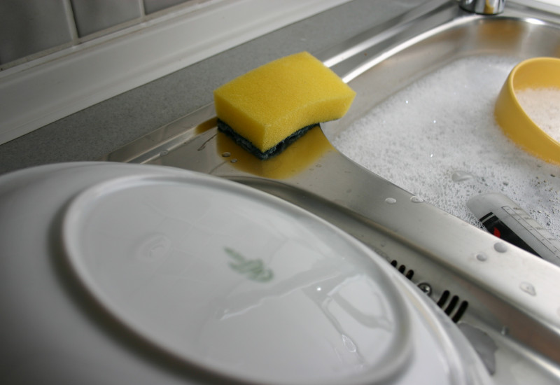 Geschirr wird in einer Spüle gewaschen.