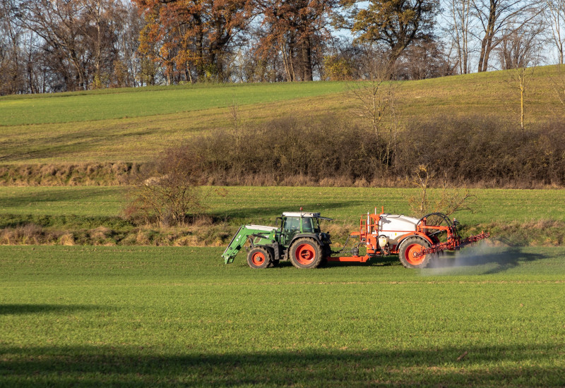 Traktor besprüht ein Feld