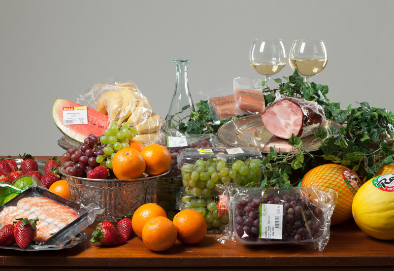 Stillleben: verschiedenes Obst, Gemüse und Fisch in Plastik verpackt wie im Supermarkt