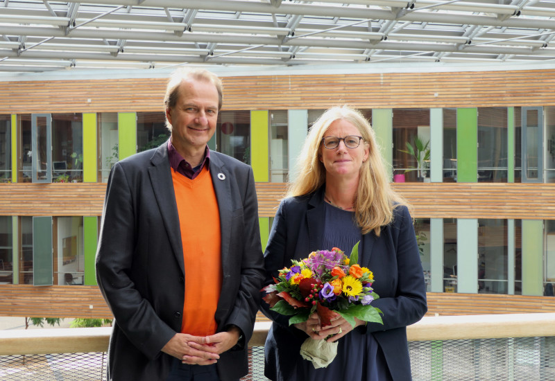 UBA Präsident Dirk Messner und Vizepräsidentin Lilian Busse mit einem Blumenstrauß