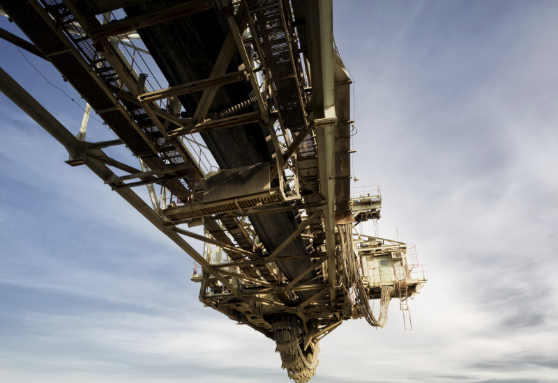 Stillstehender Schauffelradbagger auf einem Kohletagebau, man sieht bewölkten Himmel und den Tagebau, bei dem Kohle abgebaut wird