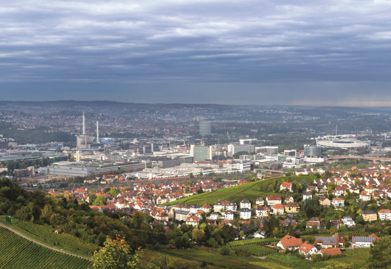 Das Bild zeigt den Blick in den Talkessel von Stuttgart hinein. Im Bildvordergrund sind Weinberge und Waldstücke zu erkennen, die Siedlungs- und Gewerbeflächen sieht man im Mittel- und Hintergrund.