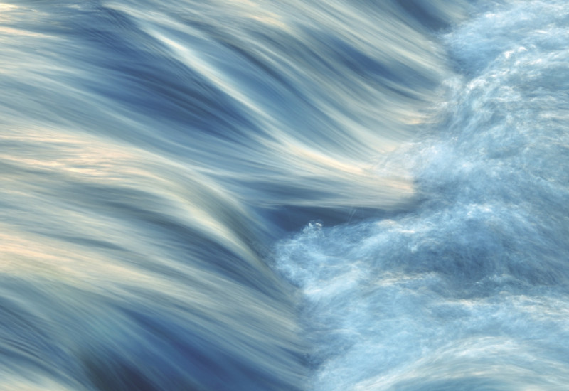 The picture shows a stream of water shooting down a rapids.