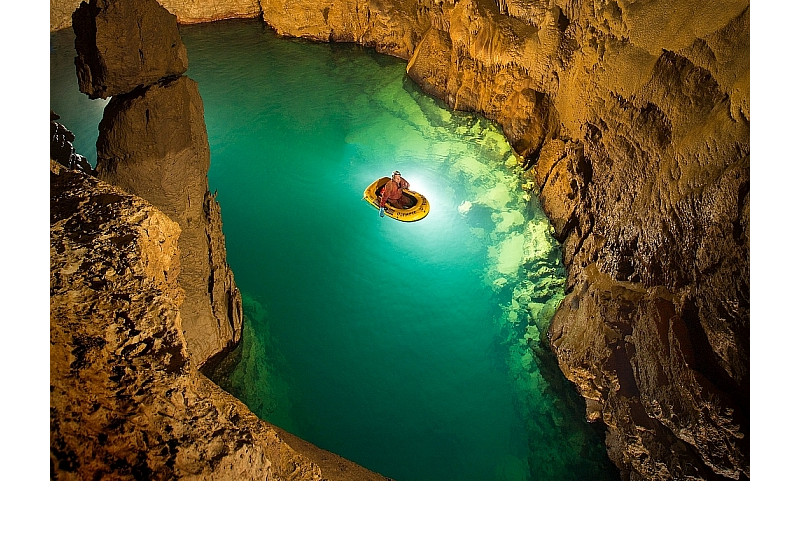 Ein Foto in der Blauhöhle. Zu sehen Grundwasser und eine Person in einem Boot.