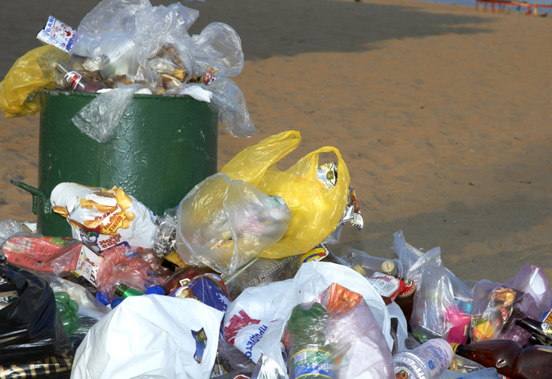 Überquellender Mülleimer am Strand