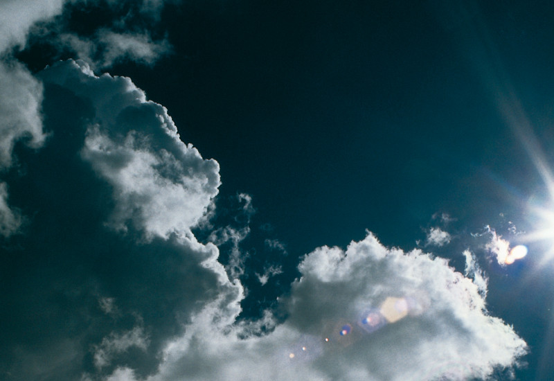 Blauer Himmel mit Sonne und Wolken