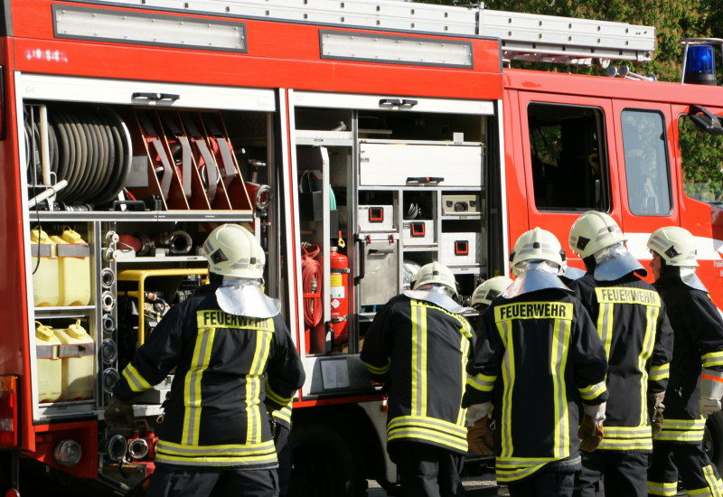 Feuerwehrmänner an einem Feuerwehrwagen