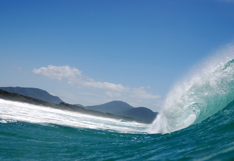Nahaufnahme einer großen Welle, die kurz davor ist in die Brandung zu stürzen