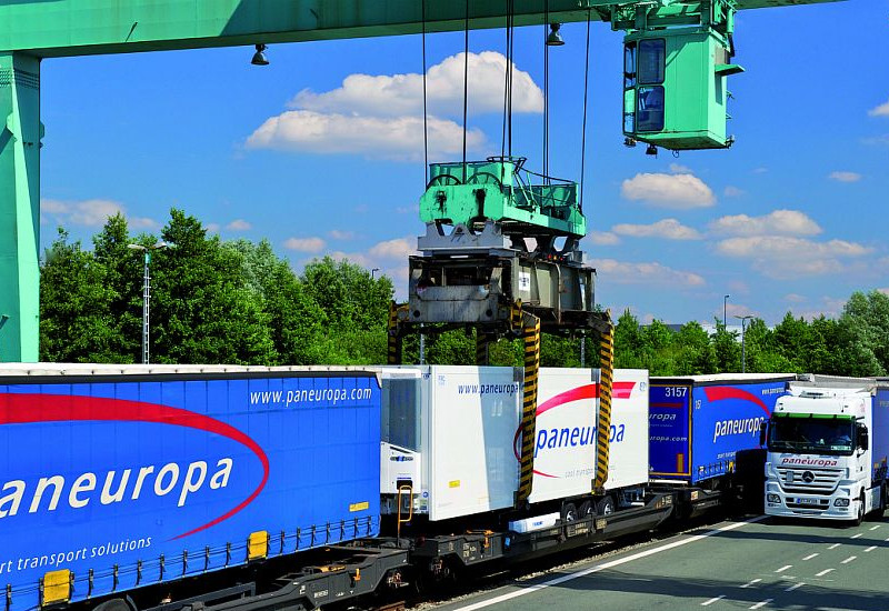 Paneuropa Anhänger werden von einem grünen Kran auf von Schienen auf die Straße verladen