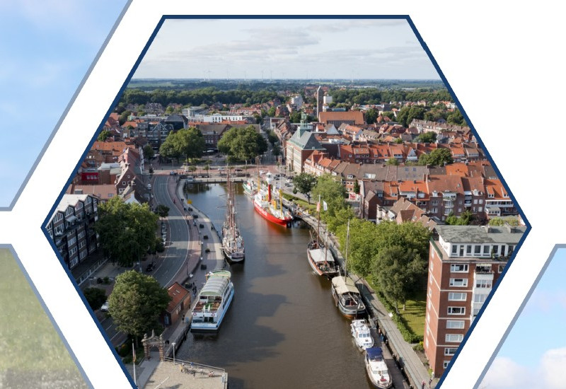 Der Blick trifft aus der Höhe auf einen Fluss, der durch eine Stadt fließt.