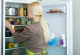 Frau steht vor geöffnetem Kühlschrank