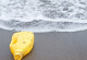 Gelbe Plastikflasche am Strand