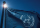 Wehende Flagge der Vereinten Nationen vor blauem Himmel