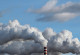 rauchende Industrie-Schornsteine vor einem bewölkten Himmel