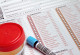 Urine and blood specimen in tubes on a questionaire for laboratory analysis
