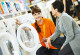 Eine Verkäuferin zeigt einer Kundin Waschmaschinen