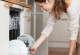 Eine Frau räumt die Spülmaschine ihrer Einbauküche ein
