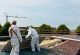 Workers remove asbestos roof sheets