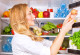 Frau vor offenem Kühlschrank