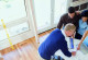 Gestaltung einer Wohnung: Einrichtungspläne und Laptop. Drei Personen: Innenarchitekt und ein junges Paar (Mann und Frau), die sich mit Einrichtungsplänen der Wohnung beschäftigen.