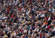 Viele Menschen sitzen nebeneinander und schauen in die selbe Richtung