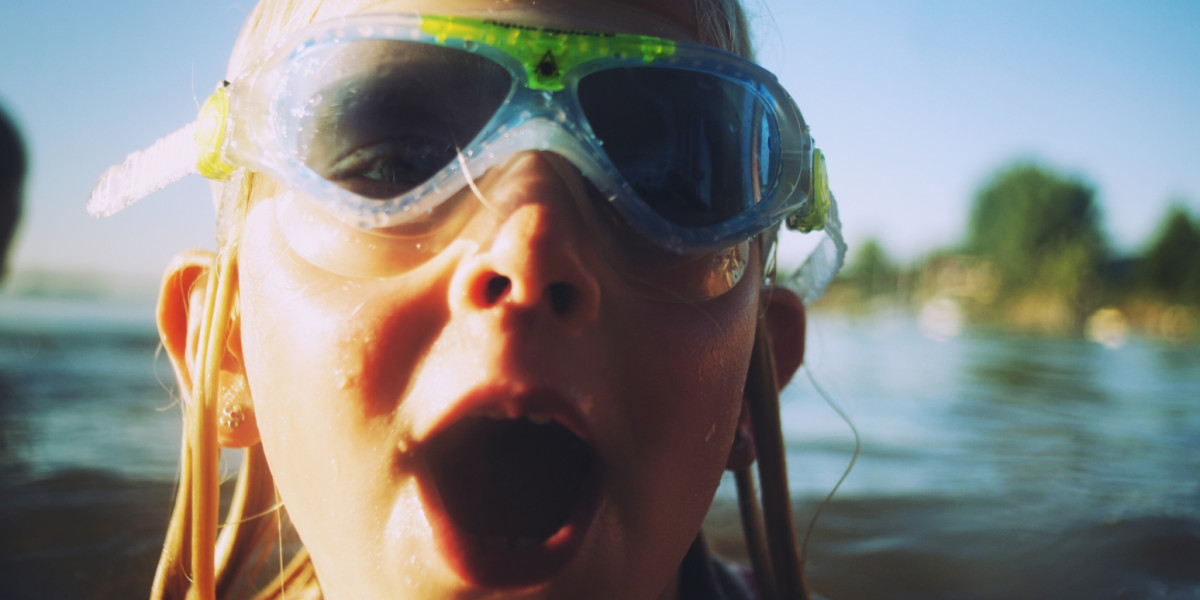 Ein Mädchen schwimmt im offenen Wasser: Sie trägt eine Schwimmbrille.