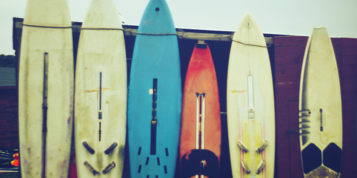 Sechs Surfbretter lehnen an einer Garage