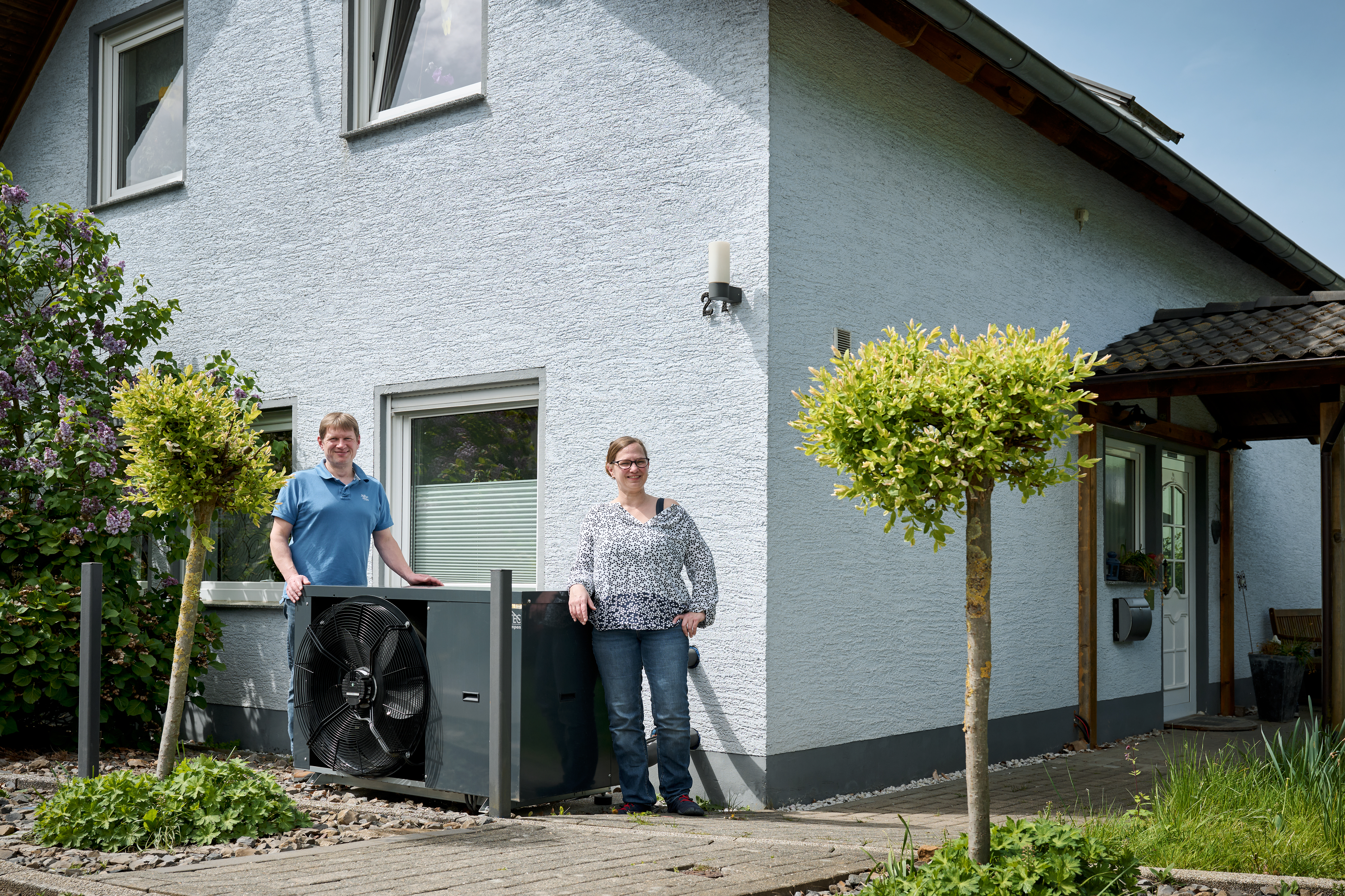Familie Krüger vor Ihrem Haus mit Wärmepumpe