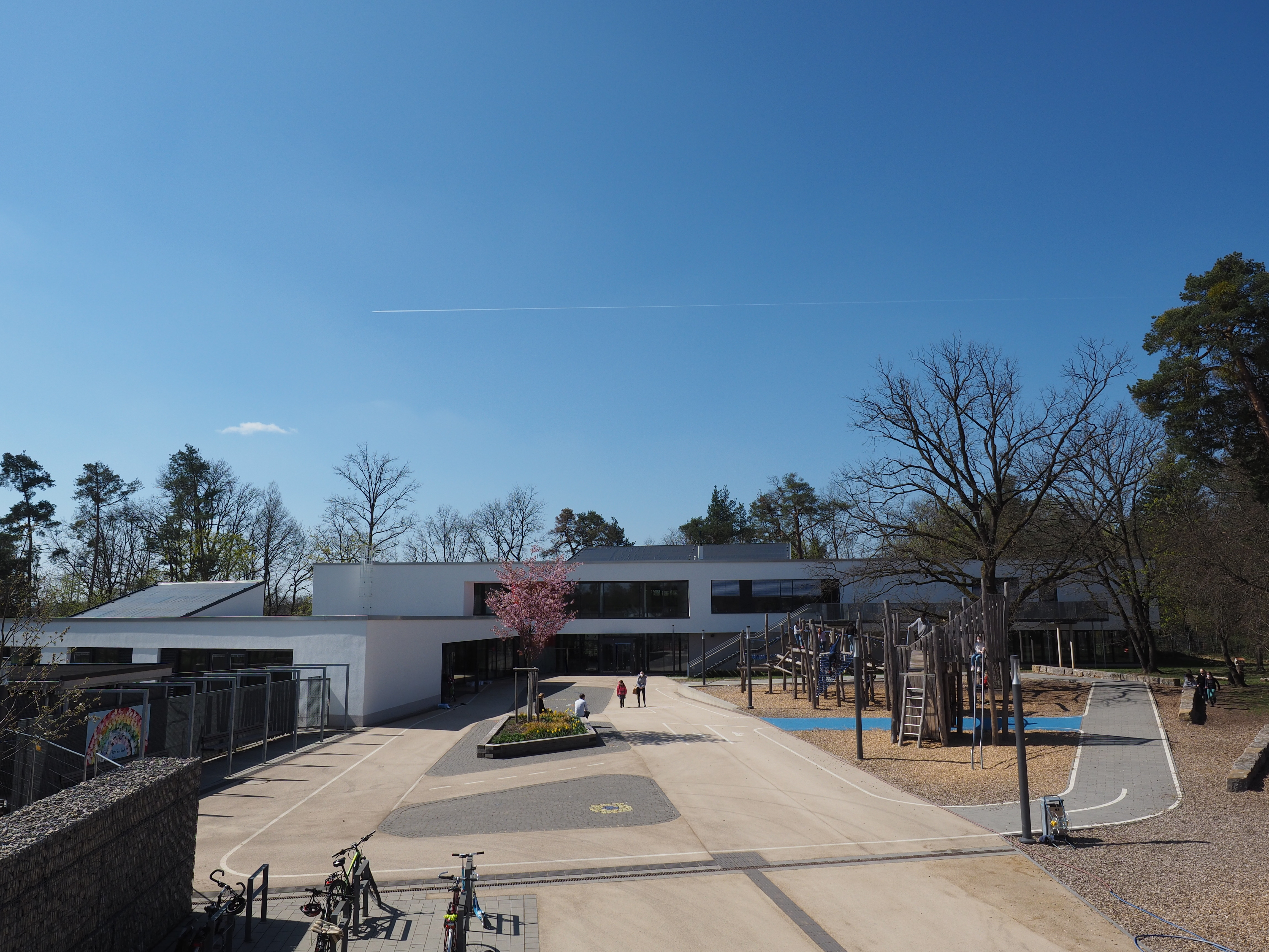 Die Gesamtansicht eines modernen Schulgebäudes mit Schulhof.