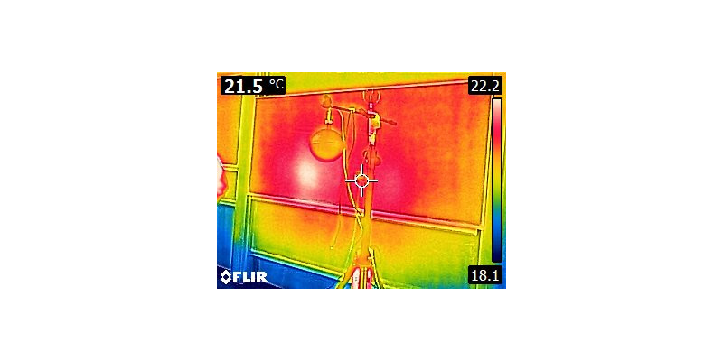 Wärmebildaufnahme, vermutlich ist eine Tafel und ein Messgerät zu erkennen, beide durch Farben als Warm gekennzeichnet.