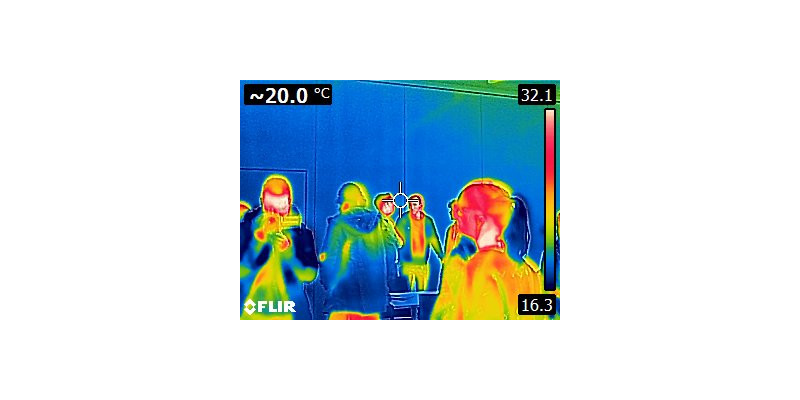 Wärmebildaufnahme aus den messtechnischen Übungen. Personen sind durch Farben als warm zu erkennen, während die Wand im Hintergrund kalt ist.