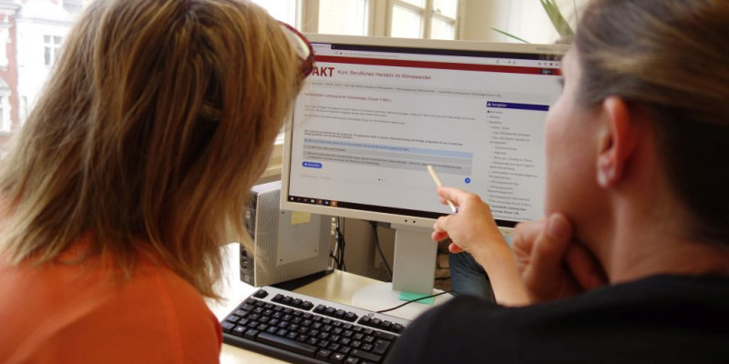 Zwei Personen schauen sich auf einem Computerbildschirm die Online-Tools des Projekts an.