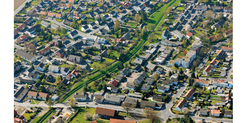 Luftbild einer Siedlung. In der Mitte des Bildes verläuft ein grüner Korridor.