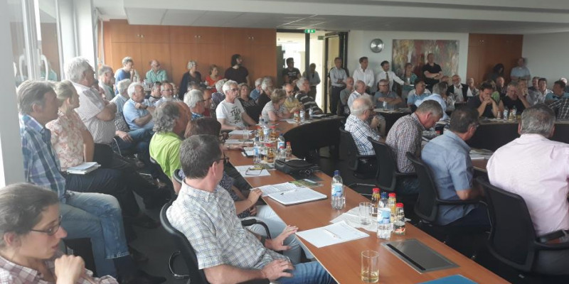 mehreren Personen sitzen und stehen in einem Veranstaltungsraum