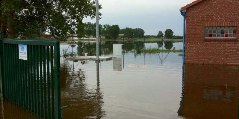 Fotografie einer Überflutung eines Hofs bzw. Parkplatzes.