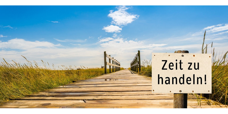 Auf einem Schild im Vordergrund steht Zeit zu handeln. Im Hintergrund führt ein Holzdünenweg optisch in den Himmel hinein.