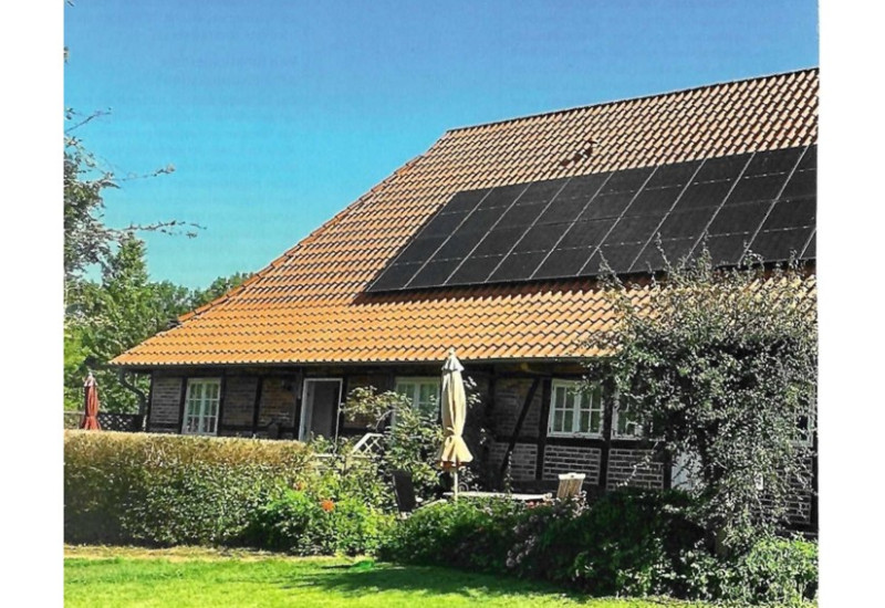 Ein historisches Fachwerkhaus mit PV auf dem Dach.