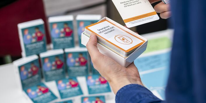 Das Klimawaage-Kartenspiel bringt unterschiedliche Alltagsentscheidungen wie "Das Handy neu kaufen" und "Kleidung secondhand kaufen" in den Vergleich.