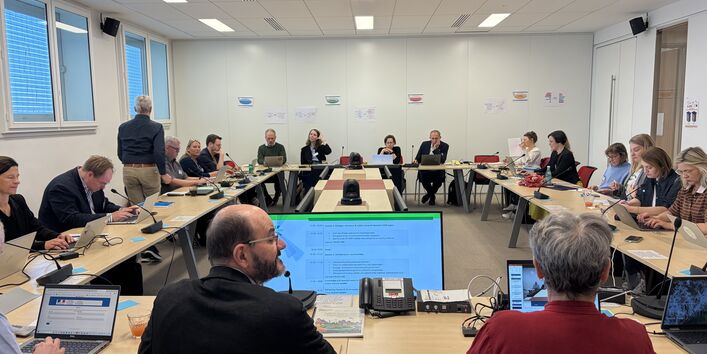 The image show people discussing in circular sitting at desks.