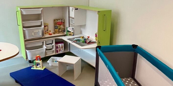 Raum mit Babybett und Spielecke