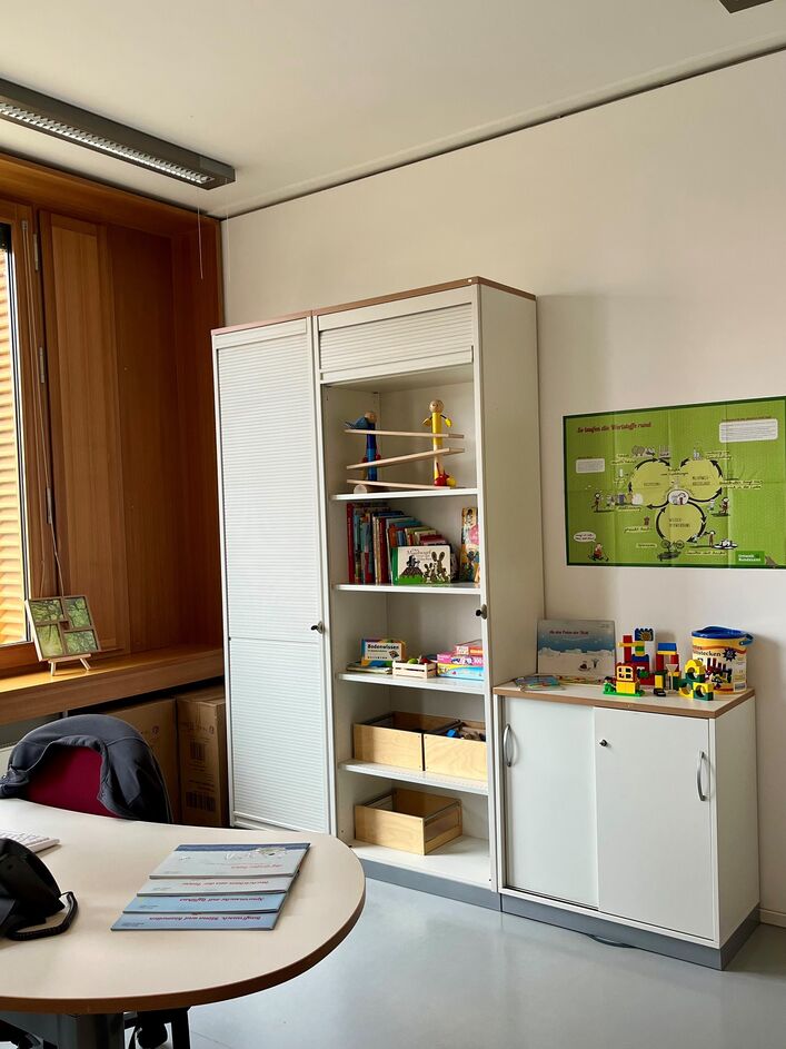 Büro mit Schreibtisch und Schrank mit Spielzeug