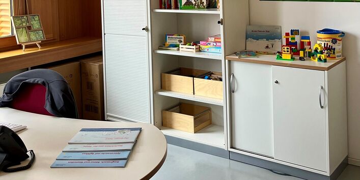 Büro mit Schreibtisch und Schrank mit Spielzeug