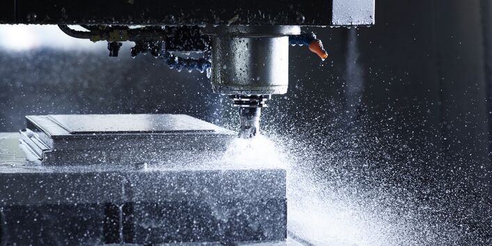 Wasser spritzt von einer CNC Fräse