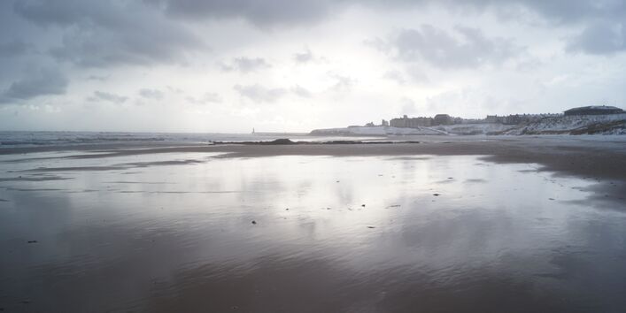 Blick vom Wasser auf einen weißen Strand