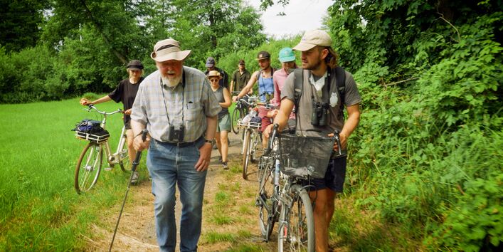 Michael Succow läuft mit weiteren Personen auf einem Waldweg