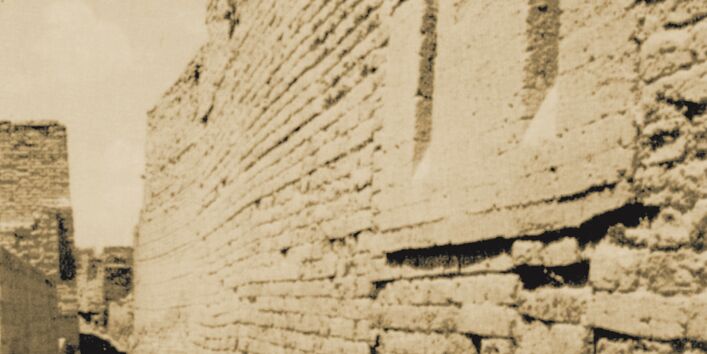 Abschüssige Auslassungen in der Mauer eines antiken Steinhauses durch die Müll aus dem Gebäude in Tongefäße auf der Straße darunter entsorgt wurde. 